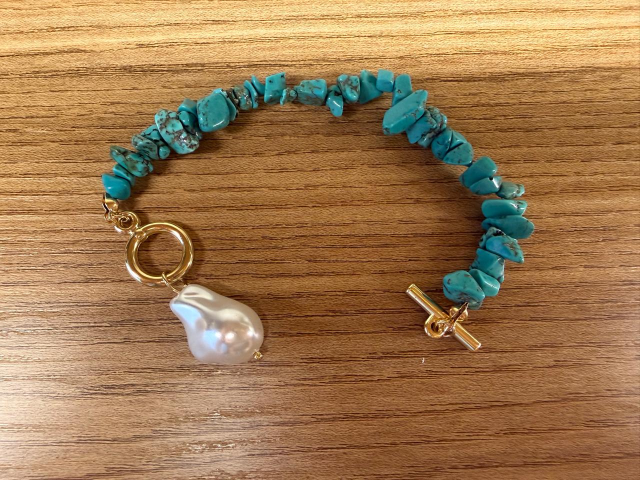 Pulseira cascalho turquesa com fecho banho de ouro com uma pérola Barroca pendurada.  15 cm