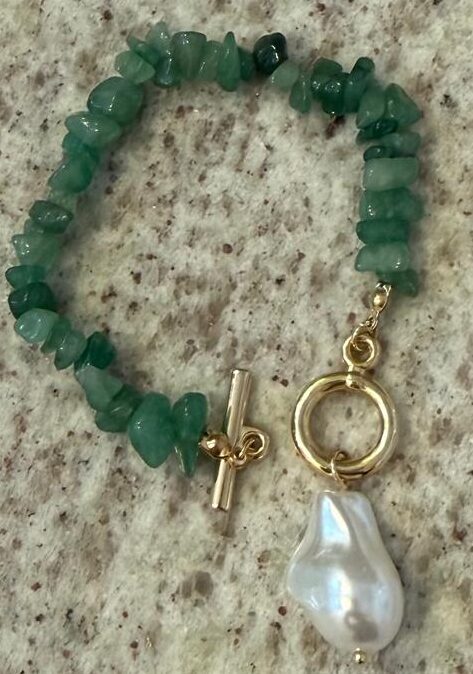 Pulseira pedras naturais em cascalho verde com fecho banho de ouro e uma pérola barroca pendurada. 15 cm