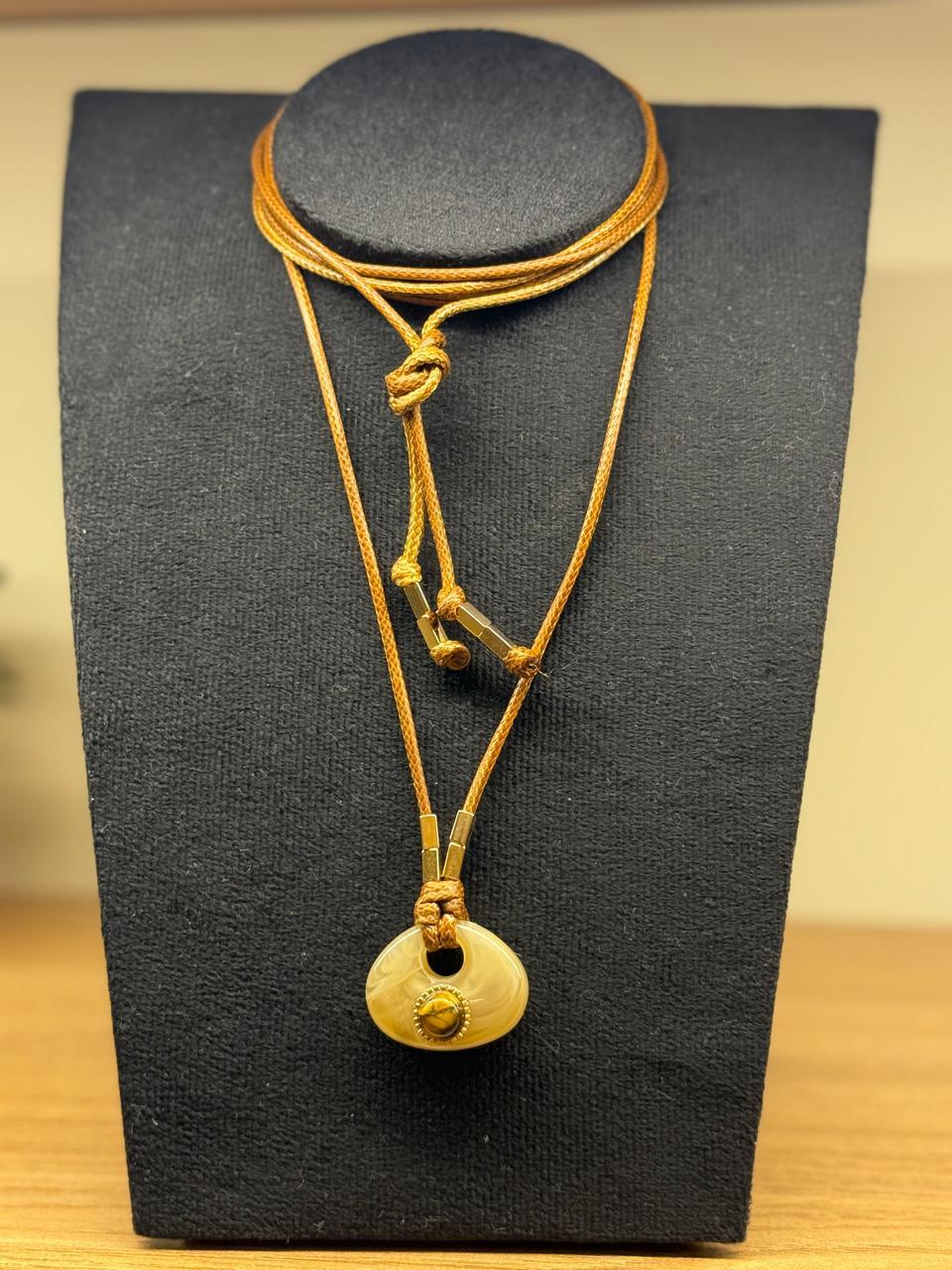 Colar no cordão encerado para várias voltas, com pingente de pedra natural com uma bola de Olho de Tigre ao centro. 1,80cm