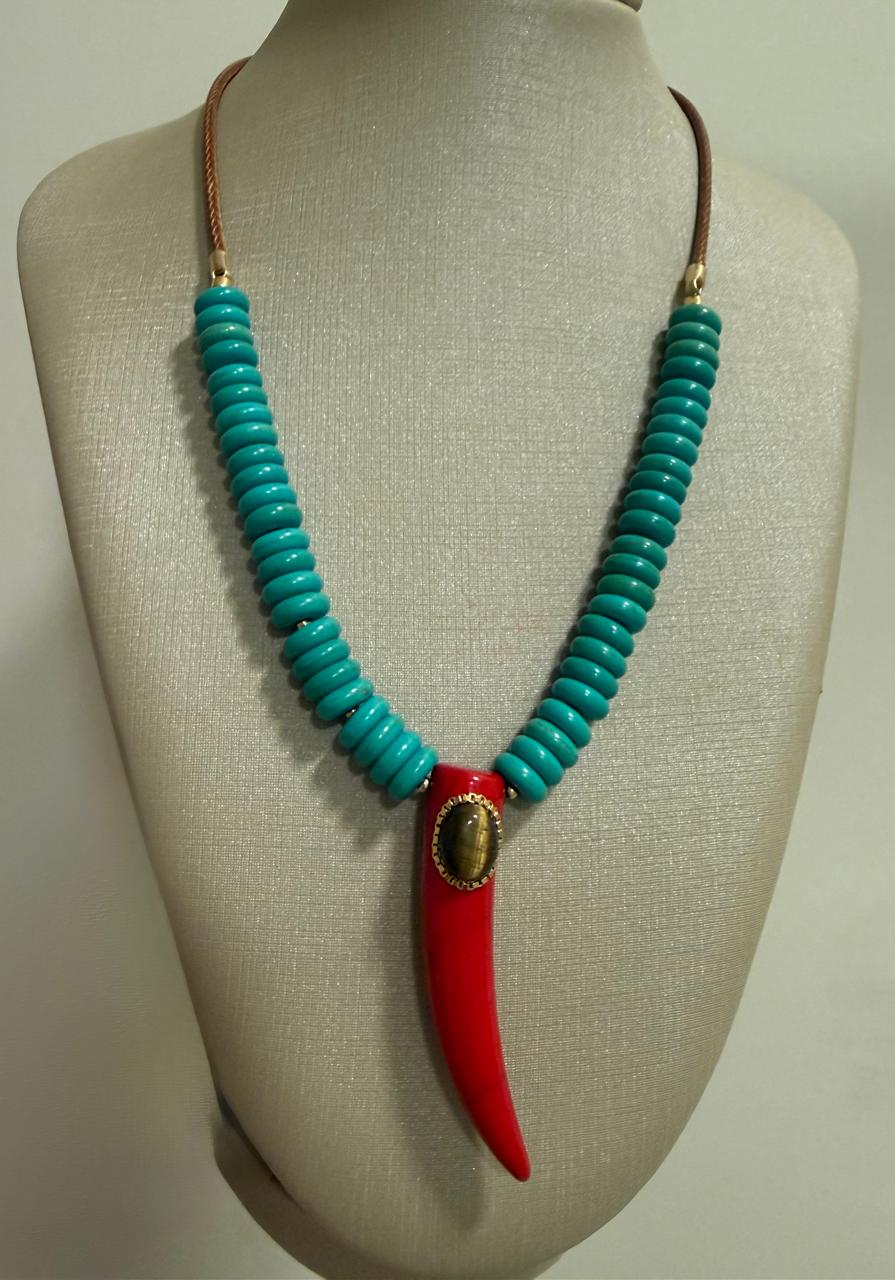Colar curto no cordão encerado com pedras turquesas e um pingente dente vermelho com uma bola de Olho de Tigre. 36cm mais 5 cm de extensor.