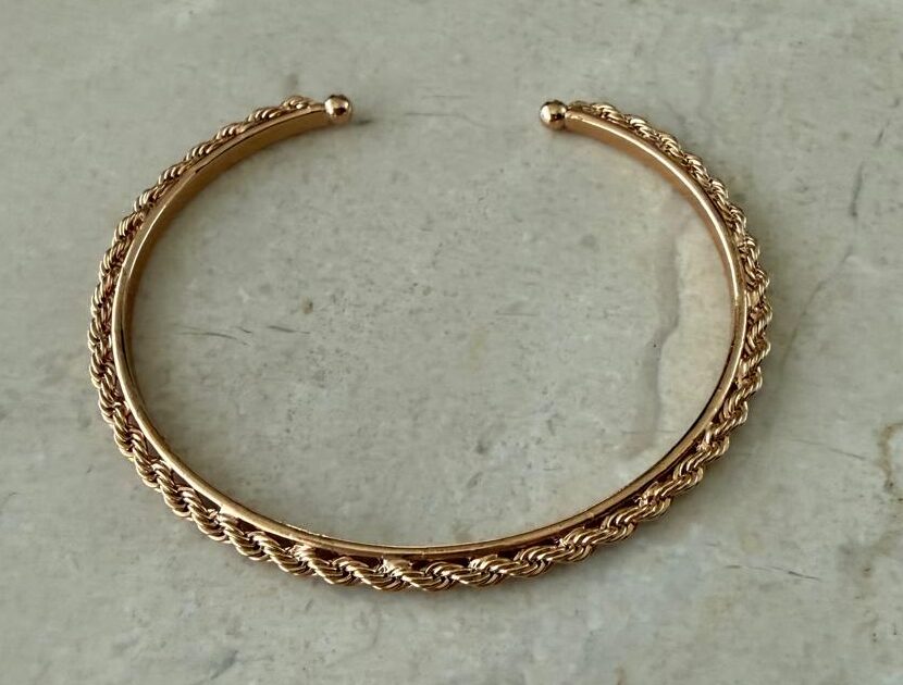 Pulseira aro com detalhe torcido em volta.