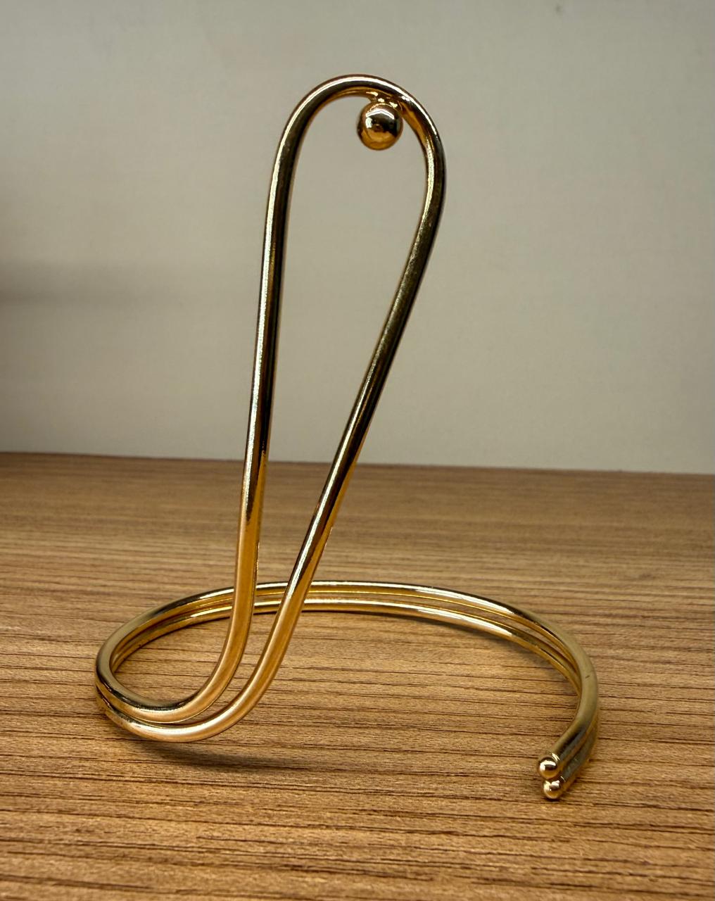 Pulseira aro no banho de ouro com detalhe de uma volta comprida para frente ou para trás.