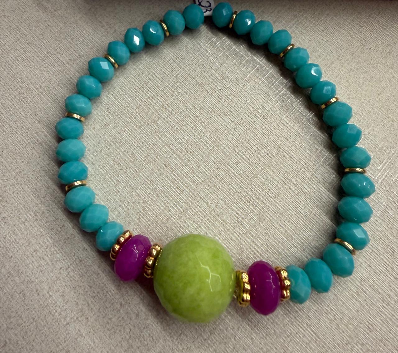 Pulseira no elástico toda em cristais turquesa, verde e rosa com detalhes no banho de ouro fazendo a diferença.