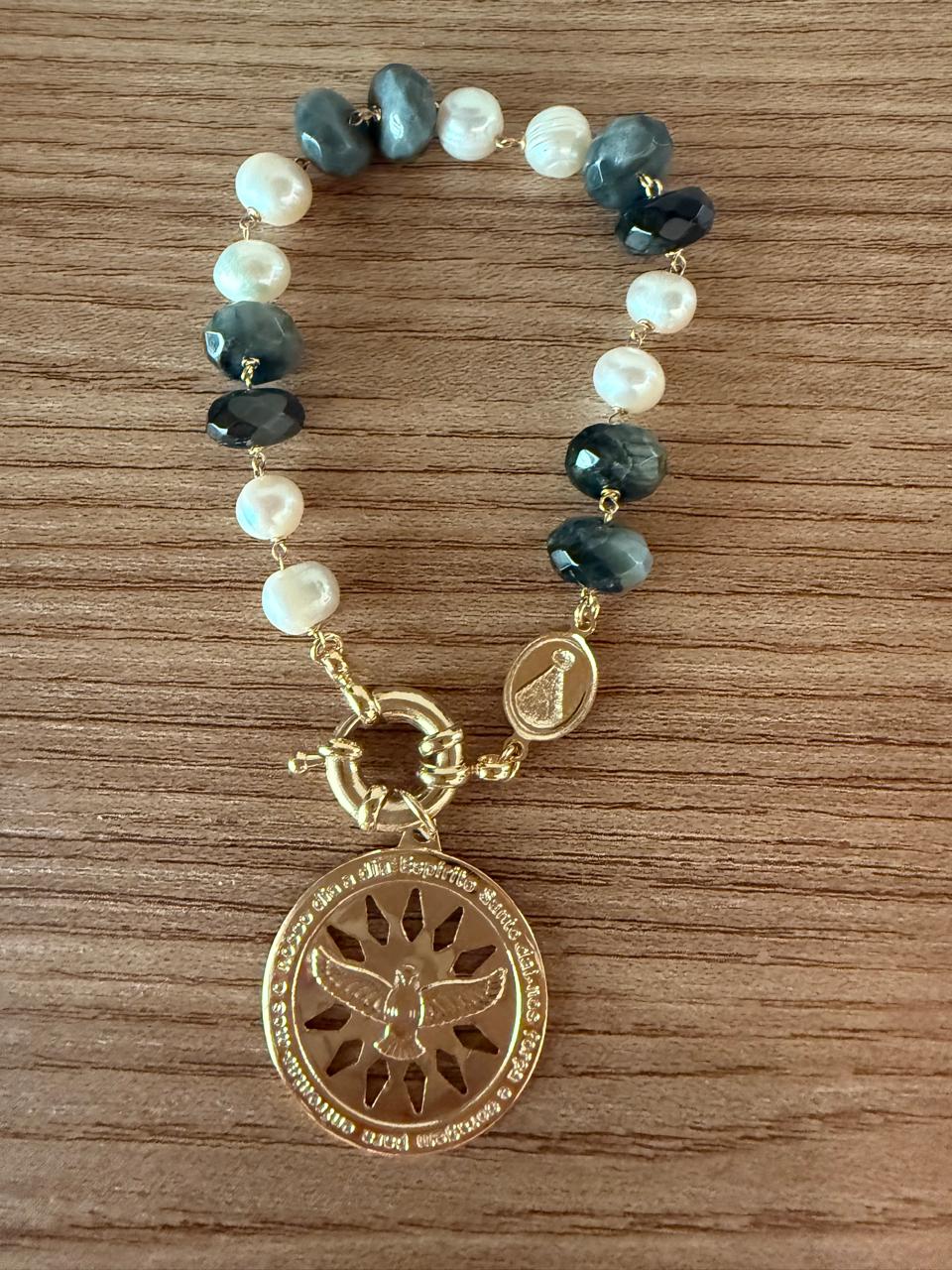 Pulseira com pedras naturais em tom acinzentado, pérolas barrocas ,pingente com Divino Espirito Santo e uma medalhinha Nossa Senhora.