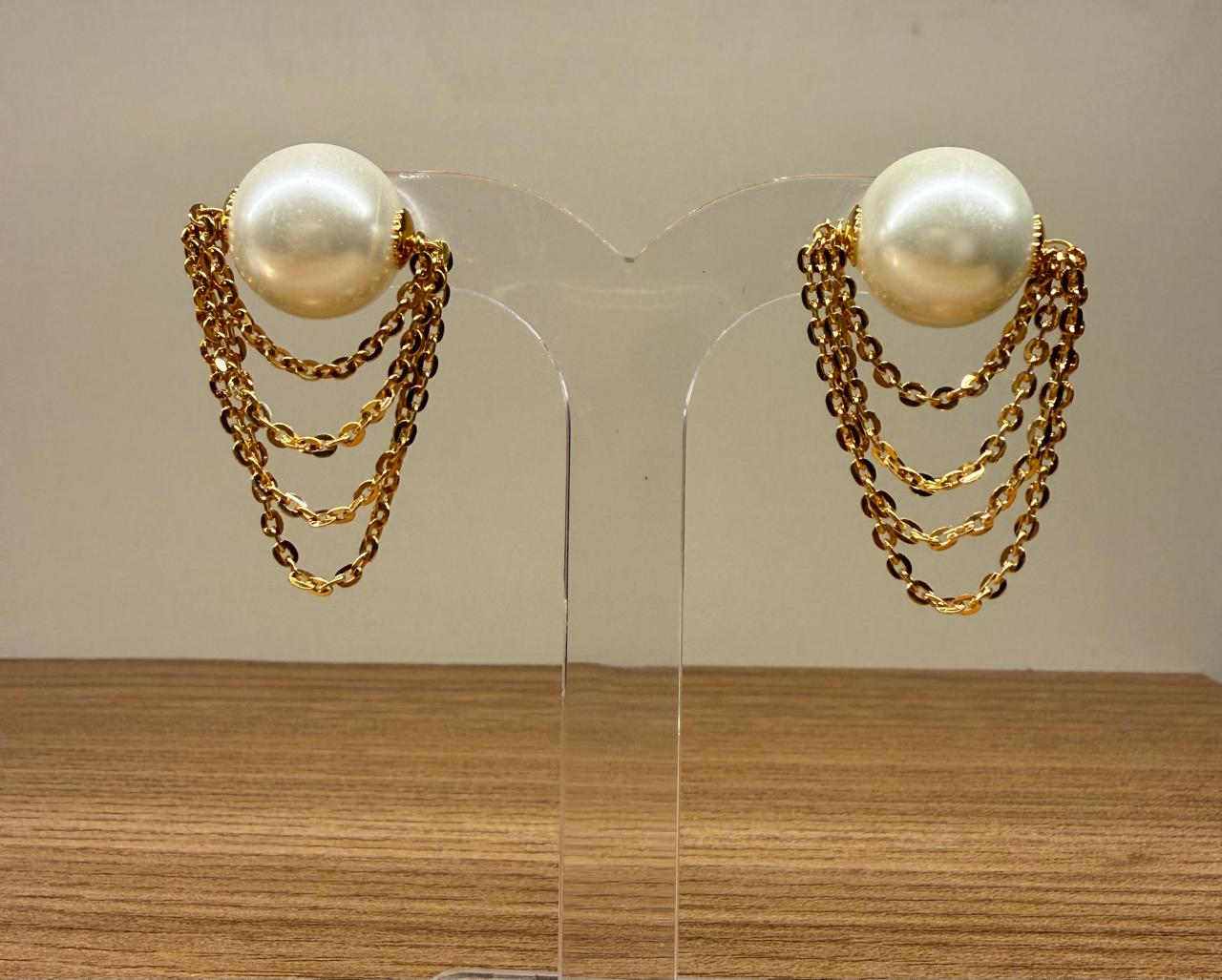 Brinco Pérola Shell com quatro correntinhas penduradas.
