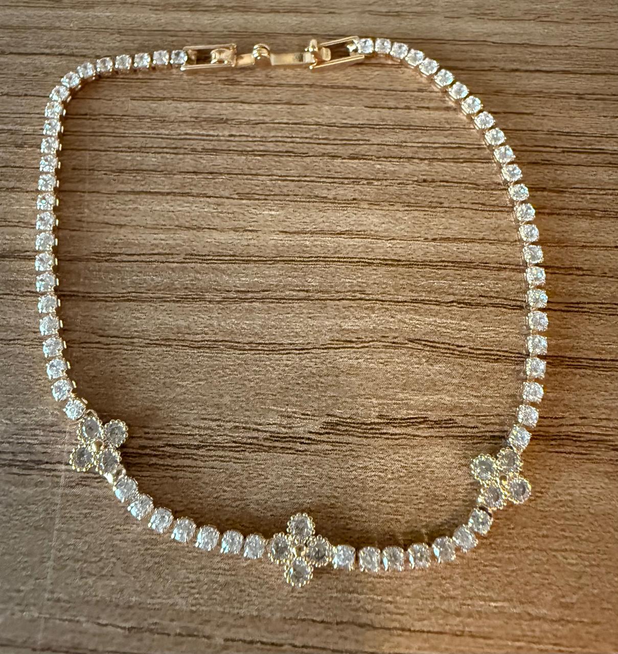 Pulseira Riviera toda cravejada de Zircônias, com três florezinhas cravejadas em cima. 19cm