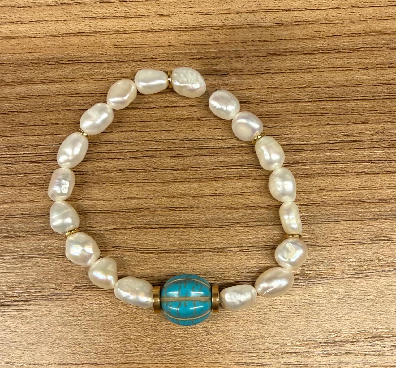 Pulseira no elástico toda de pérola Barroca com uma bola trabalhada na pedra turquesa natural, detalhes entre as pérolas dourado no banho.