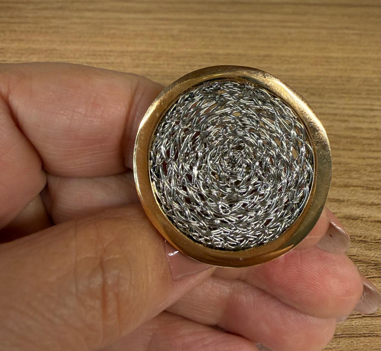 Anel regulável modelo grande , em dois banhos, redondo com uma trama no branco em cima rodeado de banho de ouro.