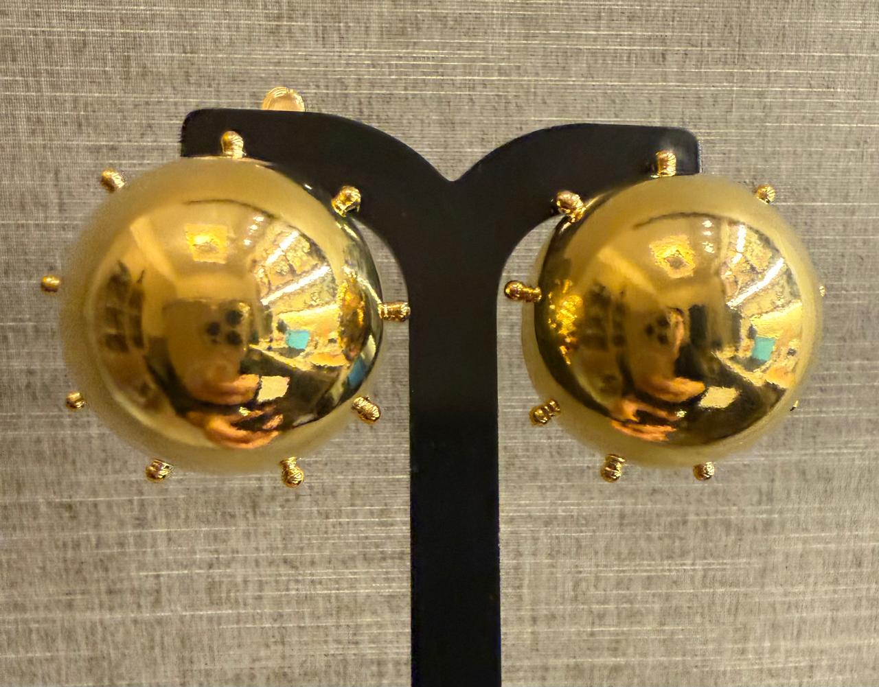 Brinco bola com detalhes de bolinhas em volta, ocado e grande. Peça leve.