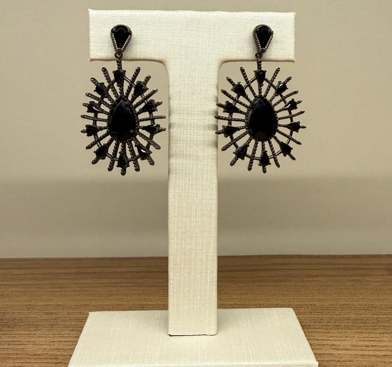 Brinco no banho negro, uma gota em pedra Ágata Negra com um pendulo com uma gota maior com raios.                                aios em volta com pedrinhas.                aios em volta com pedrinhas em Ágata Negra de