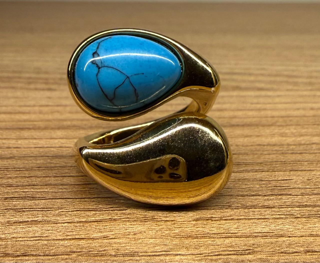 Anel regulável , aberto em cima, com uma pedra Turquesa em gota do lado de uma gota no banho de ouro.