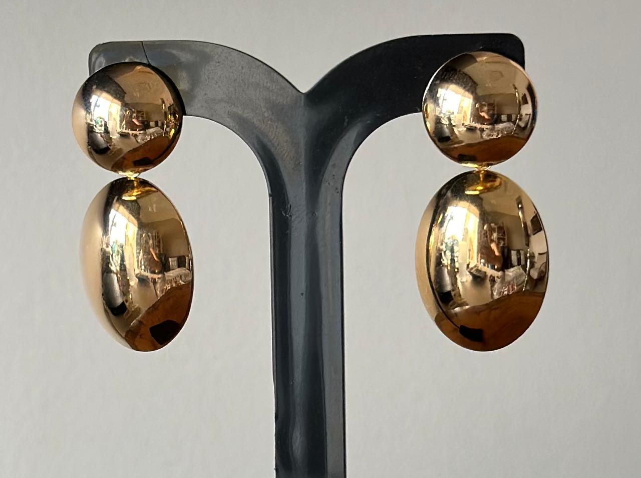 Brinco leve no banho de ouro em dois formatos, uma bola e outra oval abaulada.
