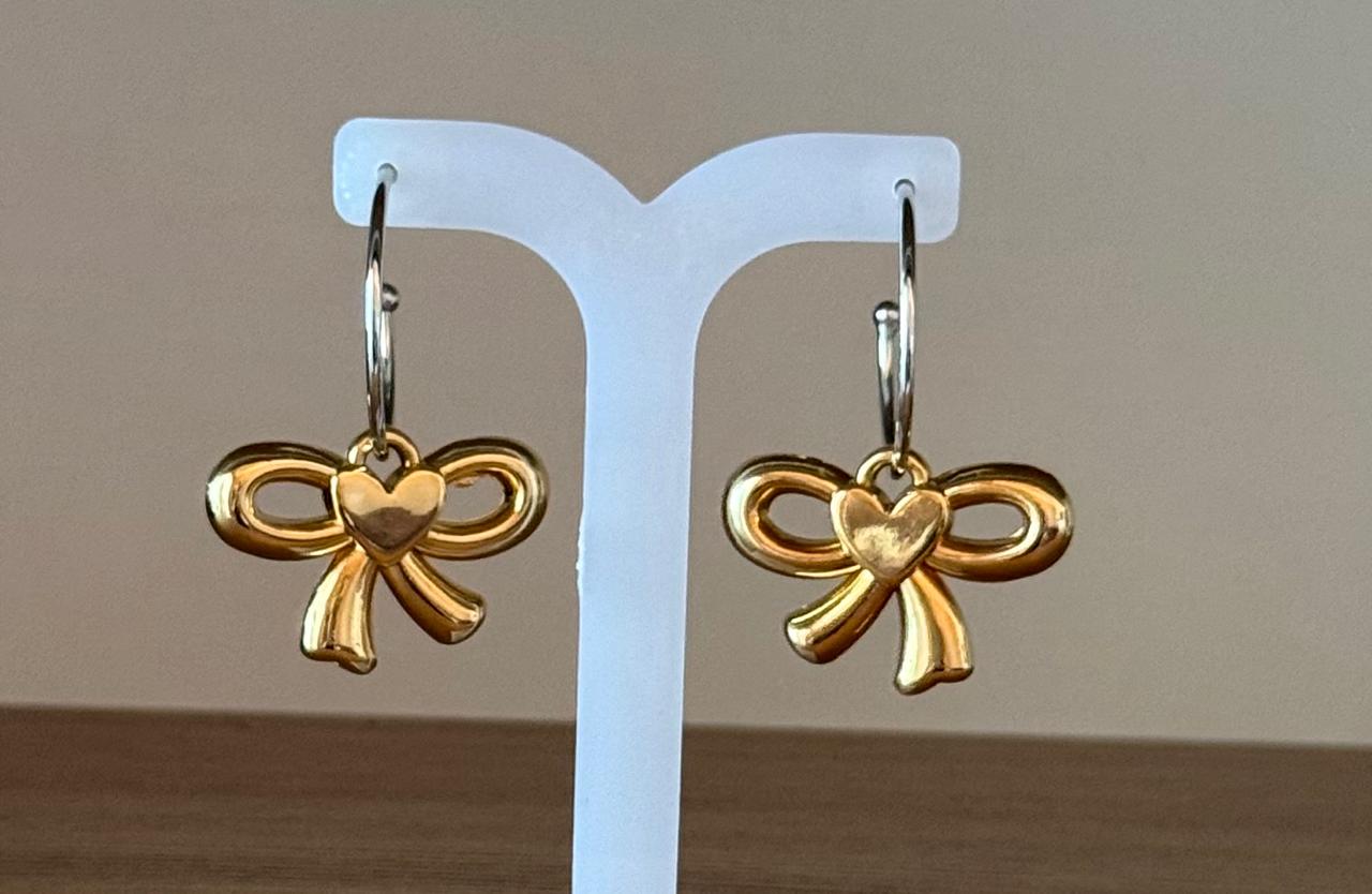 Brinco dois banhos, argola fina média no ródio branco com um laço pendurado no banho de ouro.