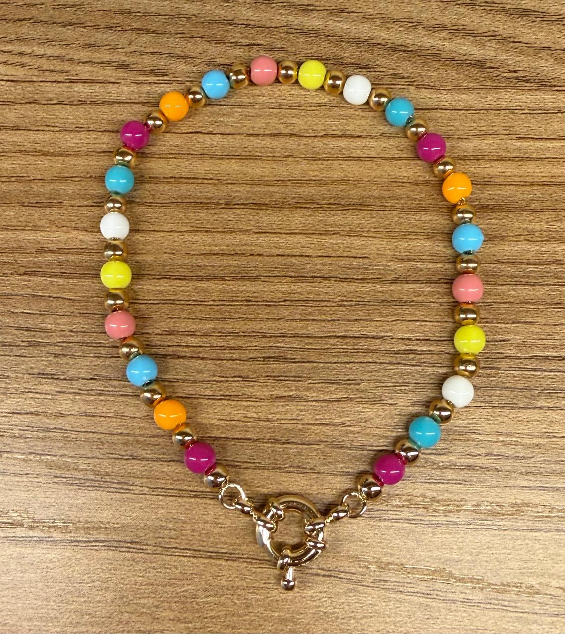 Pulseira toda de bolinhas coloridas e com bolinhas no banho de ouro. Fecho boia. 20cm