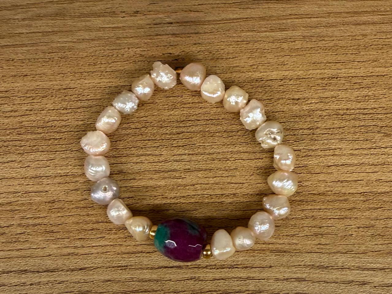 Pulseira no elástico, toda de Pérolas Barrocas com uma pedra natural rajada vinho e verde.