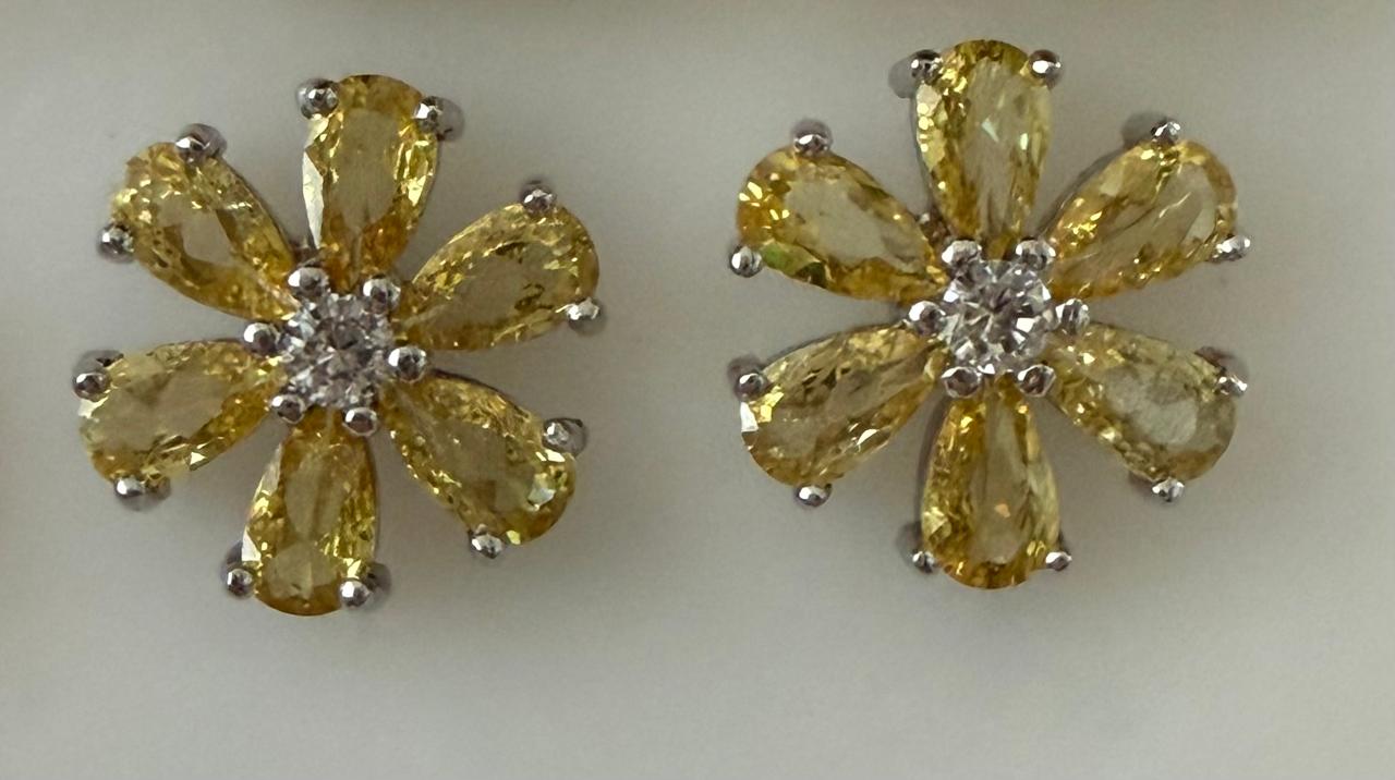 Brinco no ródio formato flor com pétalas no Cristal amarelo com uma Zircônia no miolo.