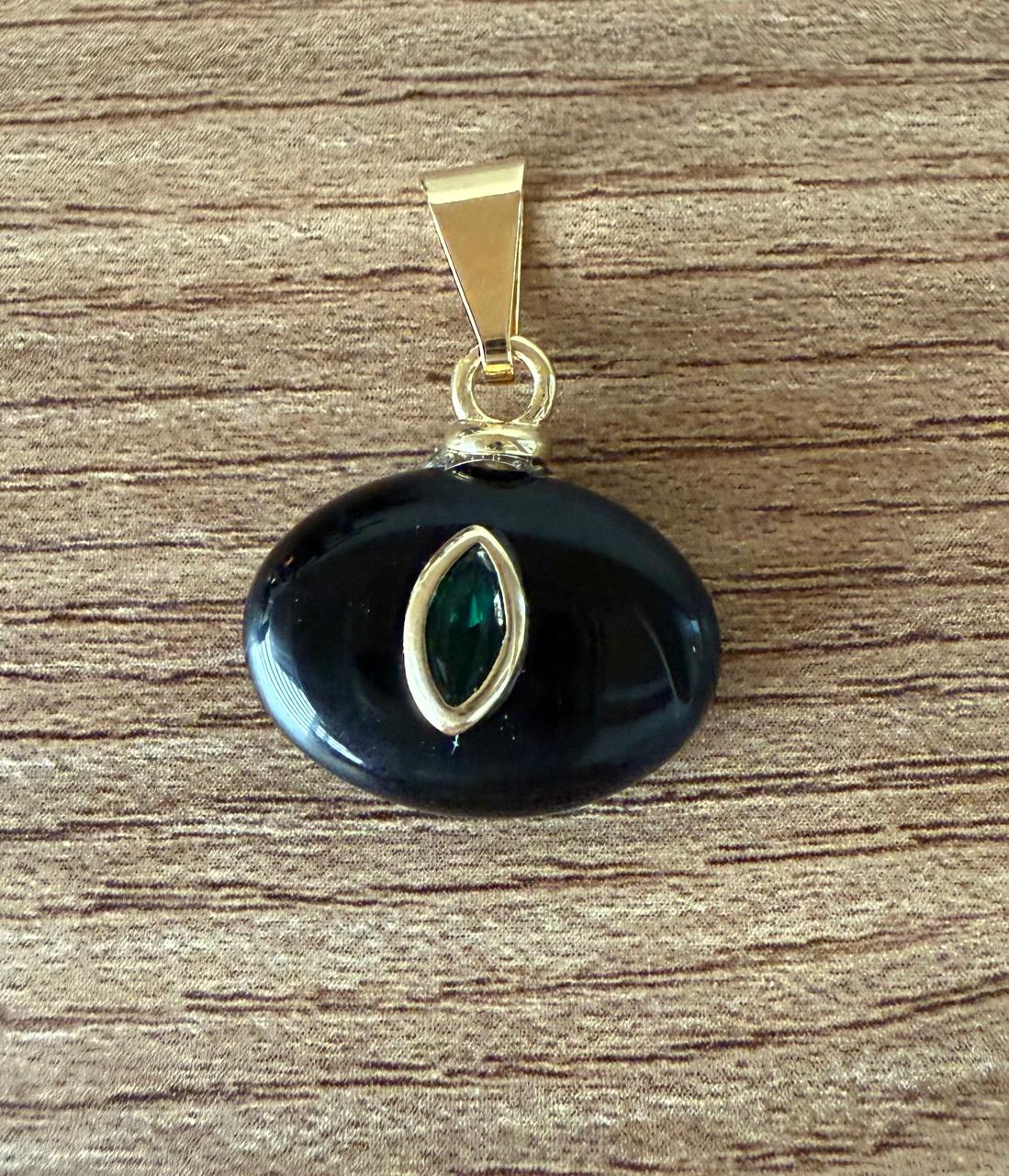 Pingente pequeno, oval na cor Ágata negra com um cristal escuro incrustado no meio. Corrente apenas sugestiva.