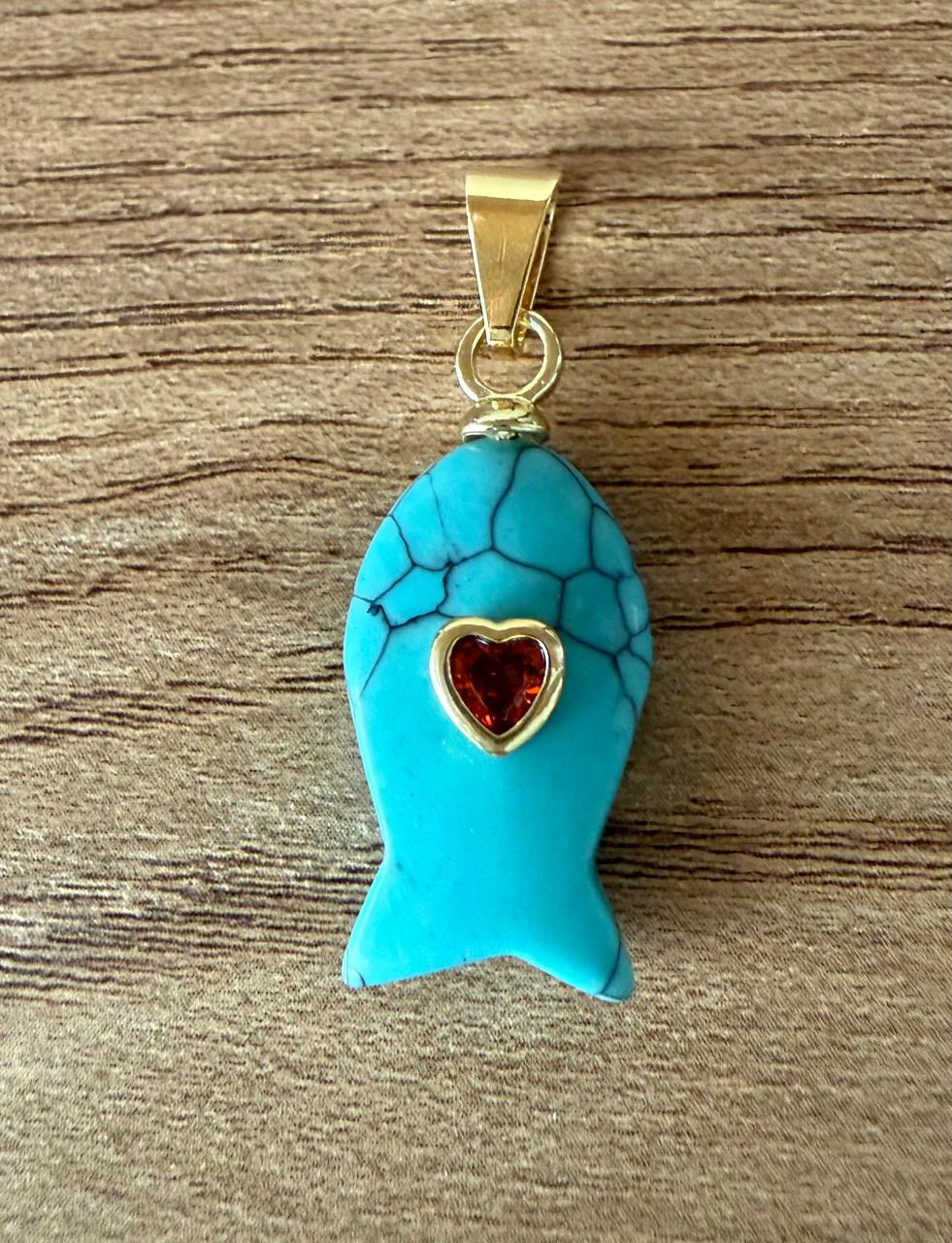 Pingente formato peixinho de pedra turquesa com uma  pedra cristal rosa incrustada. Colar de courinho apenas sugestivo.