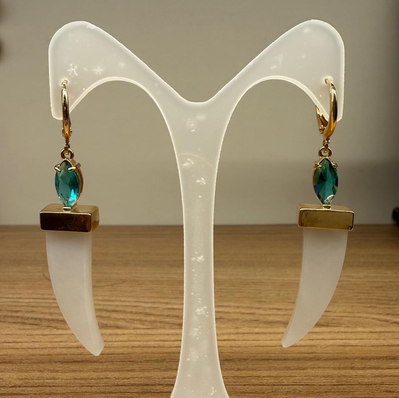 Brinco argolinha com uma gota de cristal verde com um dente madrepérola pendurado.